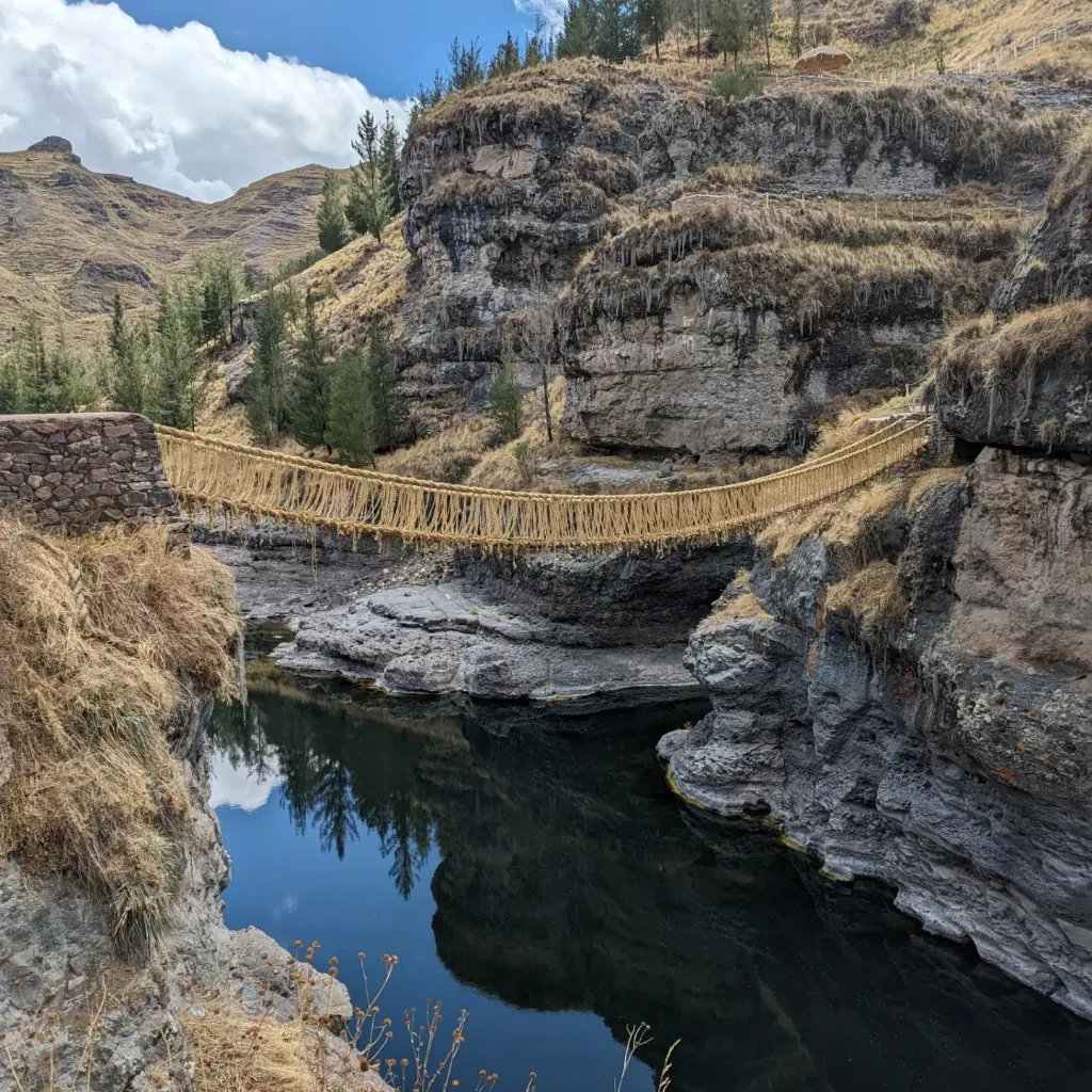 Ichu Inca bridge reflected on the river at Q'eswachaka